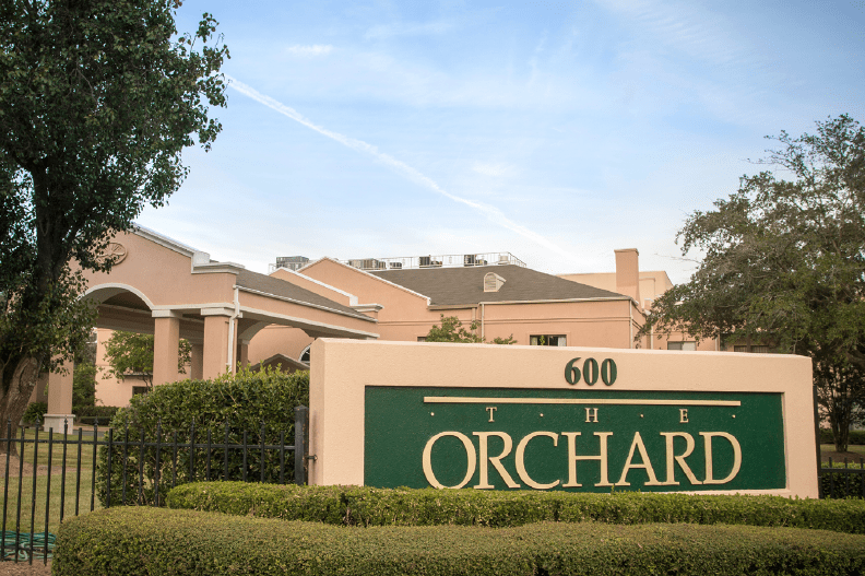 Entrance sign for 'The Orchard' residential complex.