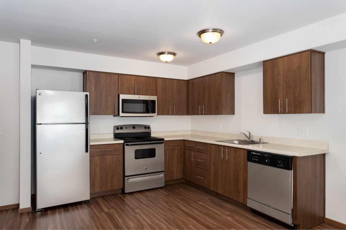 Modern kitchen with stainless steel appliances and wooden cabinets.
