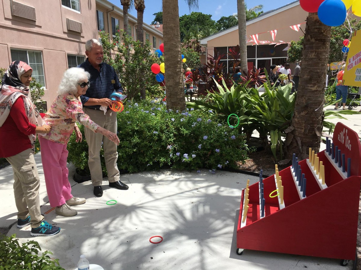 A couple plays a ring toss game during an outdoor event.
