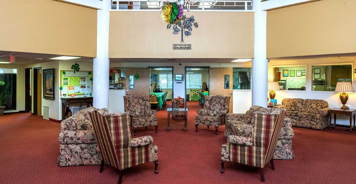 A comfortable seating area in a lobby decorated with patterned chairs and festive ornaments.