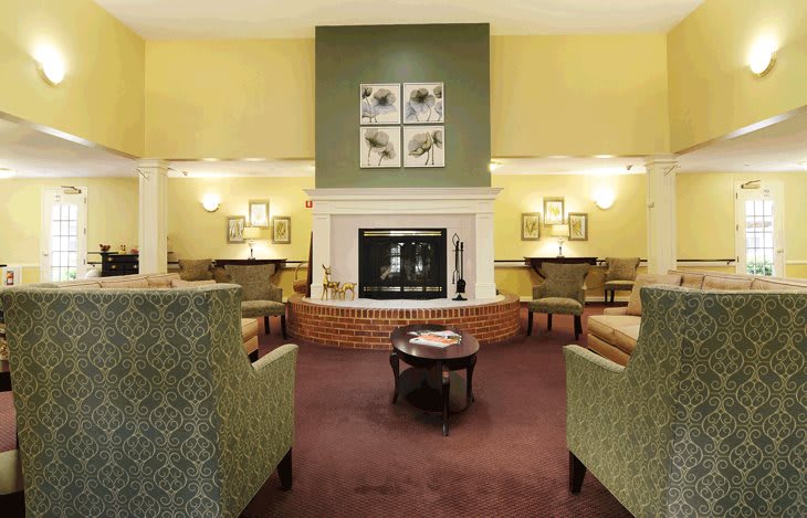 A cozy living room with a central fireplace and comfortable seating.