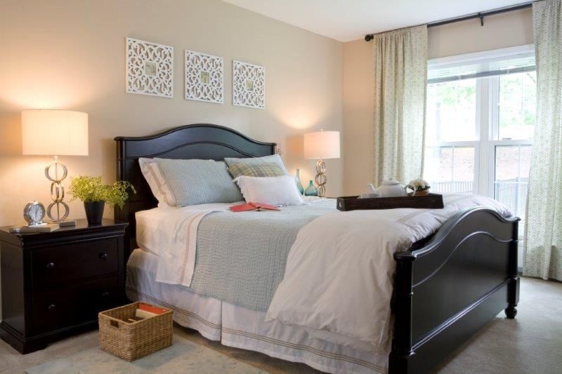 A cozy and well-decorated bedroom with a neatly made bed, stylish decor, and soft lighting.