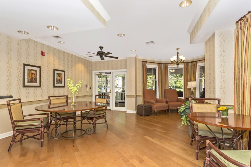 A spacious living room with elegant decor, featuring a seating area and wood flooring.