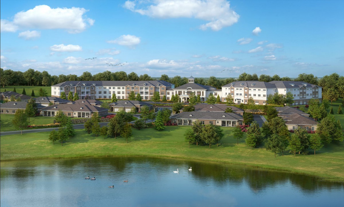 A serene residential community with buildings surrounded by greenery and a calm lake under a clear blue sky.