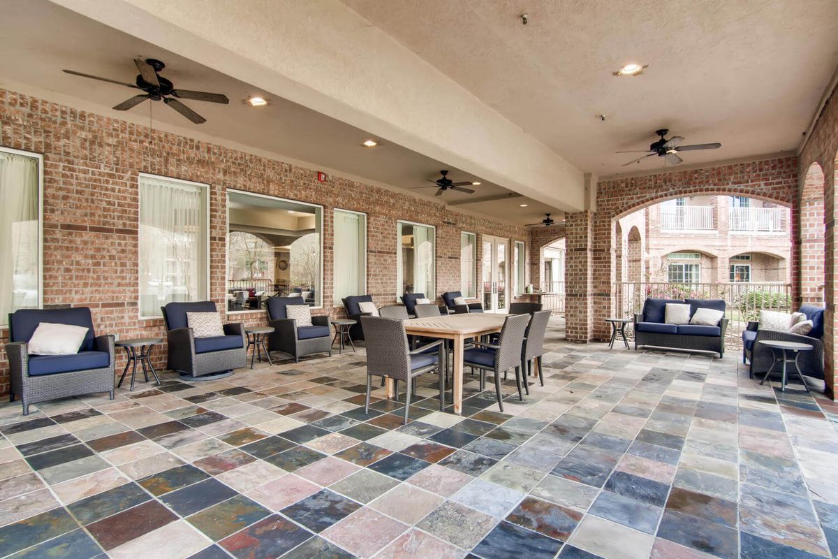 A spacious outdoor patio with comfortable seating and a tiled floor.