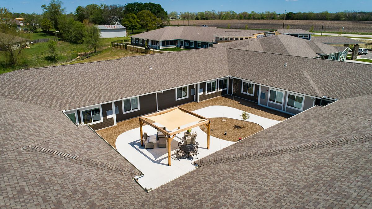 Aerial view of a building complex featuring a central courtyard with a pergola.