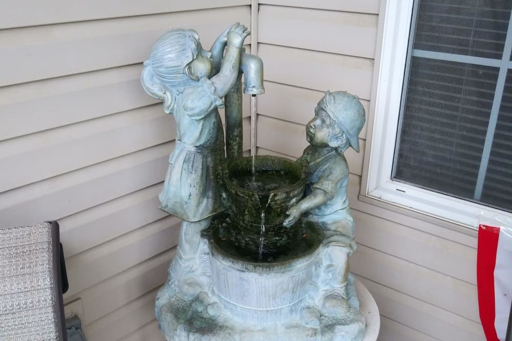 A decorative statue fountain depicting two children at a well.
