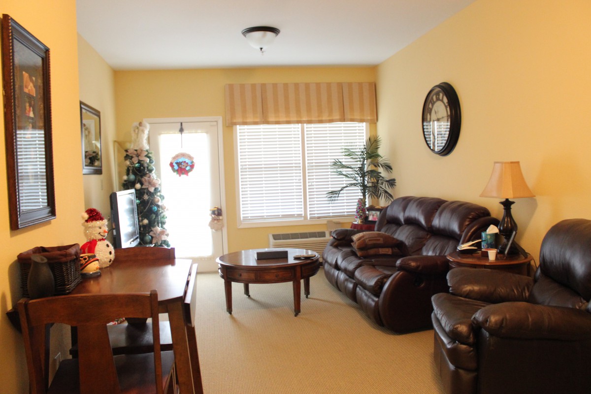 Cozy living room with a sofa, table, and decor next to a large window.