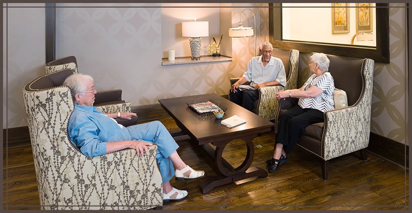 A group of people having a conversation in a cozy living room setting.