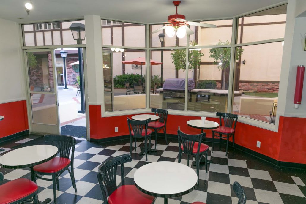 A retro-style cafe with checkered flooring and red and black decor.