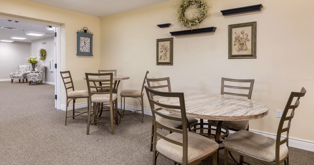 A cozy dining area with wooden tables and chairs, adorned with wall decorations.