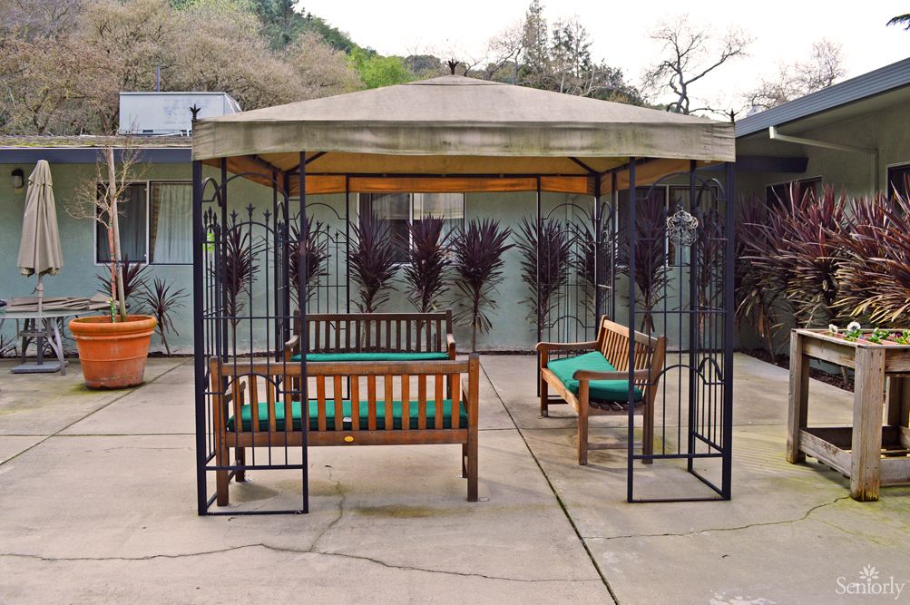 A cozy gazebo setup with benches on a patio.