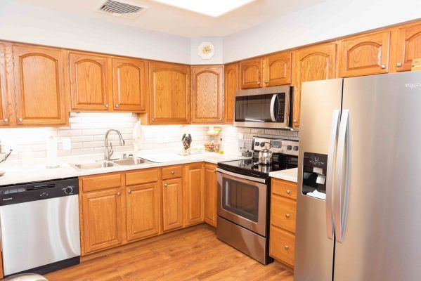 A modern kitchen with wooden cabinets and stainless steel appliances.