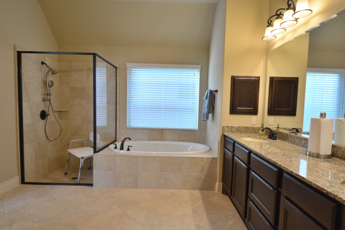 A modern bathroom featuring a bathtub, separate shower, and dual sink vanity.