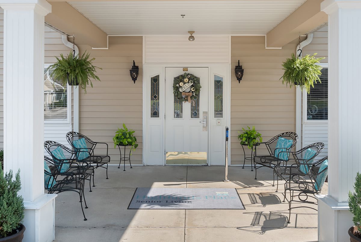 A welcoming entrance with outdoor seating and decorative plants.