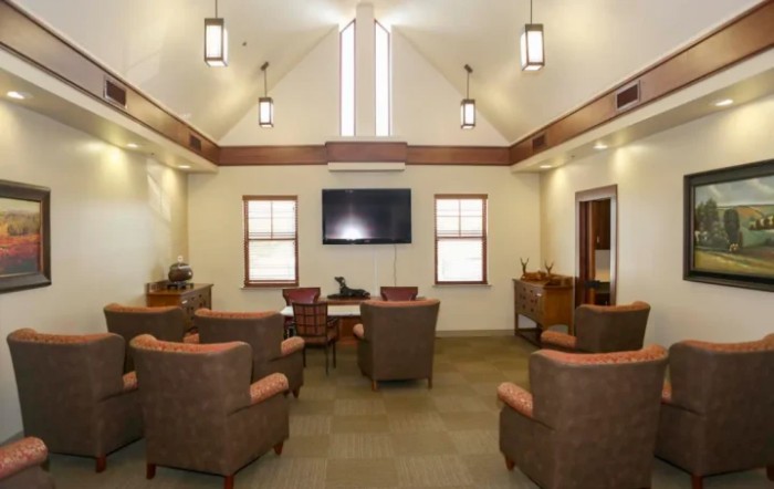 A modern lounge area with comfortable chairs and a large television.