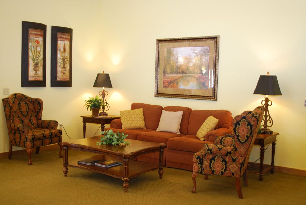 A cozy living room with warm-toned furniture and decorative artwork.
