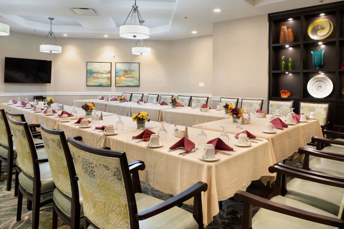 A conference room set up with a long table, elegantly arranged with napkins and decorations.