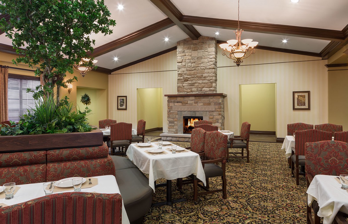 A cozy restaurant interior with a fireplace and neatly set tables.