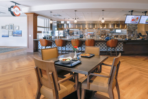 A modern dining area featuring a stylish kitchen, wooden chairs, and a well-set table.