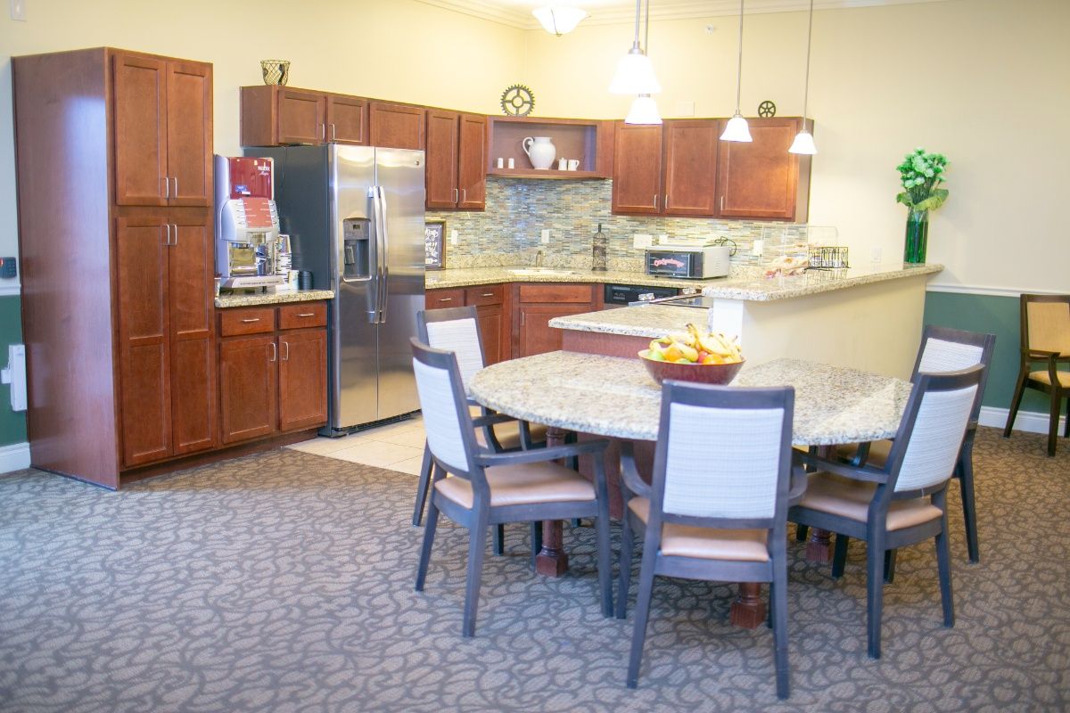 A modern kitchen with wooden cabinets, stainless steel appliances, and a round dining table.