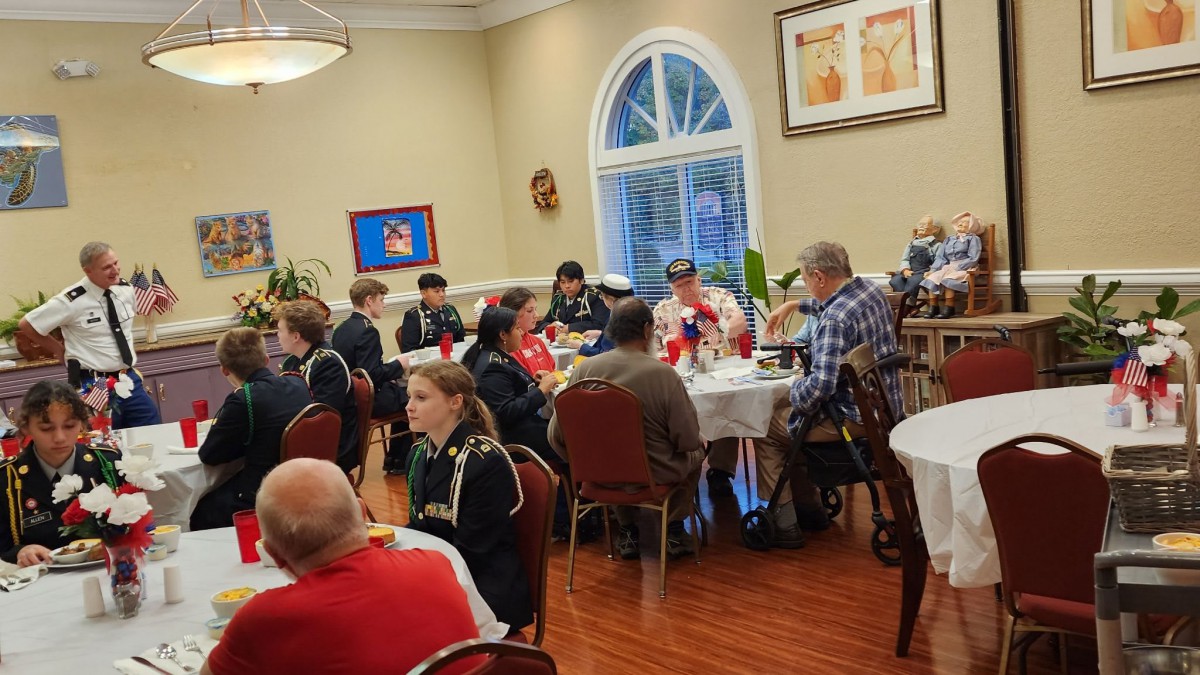 A group of people gathered around tables at an indoor dining event.