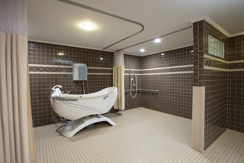 A spacious modern bathroom featuring a sleek bathtub and shower, designed for comfort and accessibility.