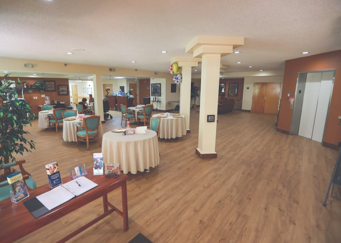 A spacious lobby with tables and columns, featuring a welcoming reception area.