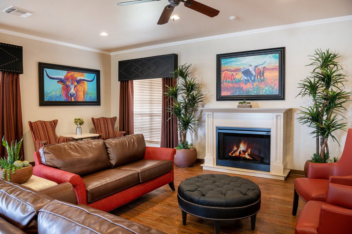 A cozy living room featuring a sofa, fireplace, and colorful artwork.