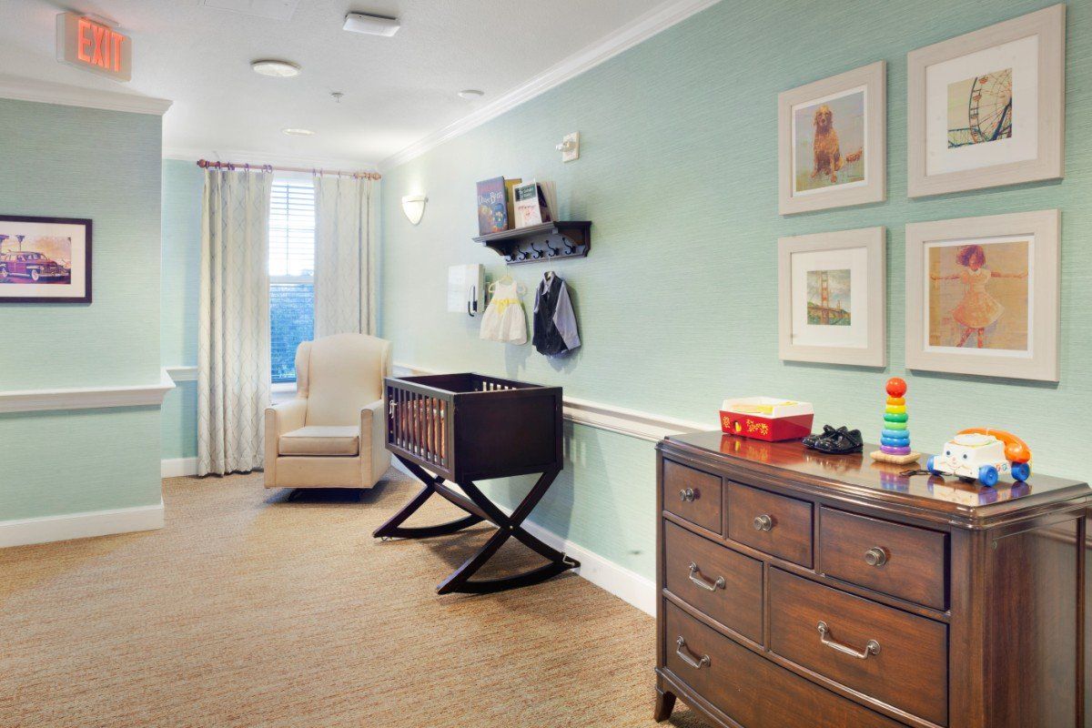 A cozy nursery with a rocking chair, changing table, and dresser, accented by pastel-colored walls and charming decor.