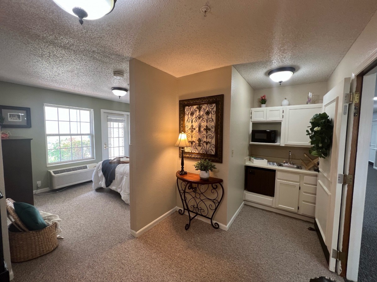 A cozy apartment with a bedroom and kitchenette.