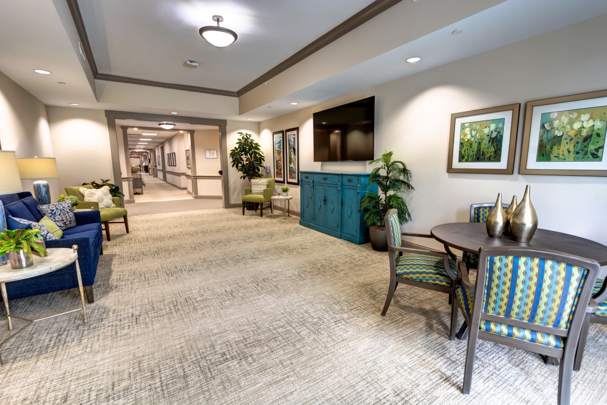 A well-decorated hallway with seating, artwork, and plants.