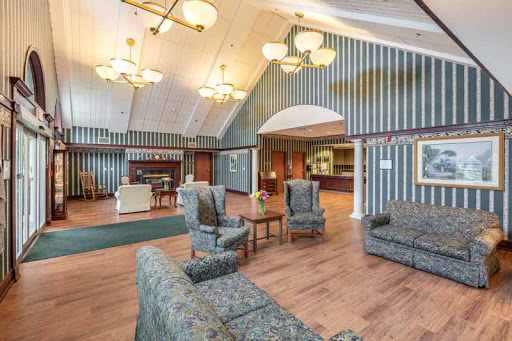 A spacious and elegantly designed lobby featuring comfortable seating, stylish chandeliers, and decorative striped walls.