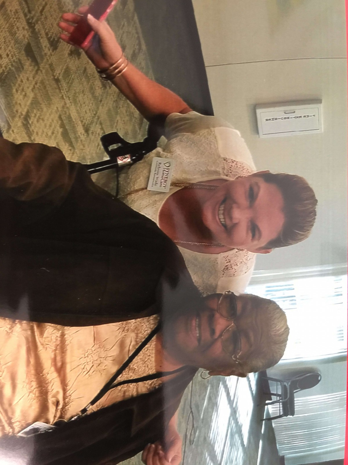 Two people smiling for a selfie indoors.