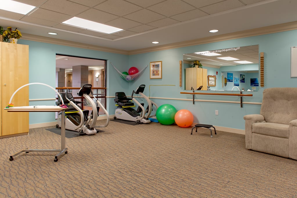 A well-equipped fitness room with stationary bikes and exercise balls.