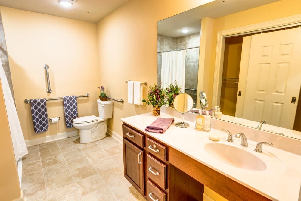 Modern bathroom with a sink, mirror, and toilet.