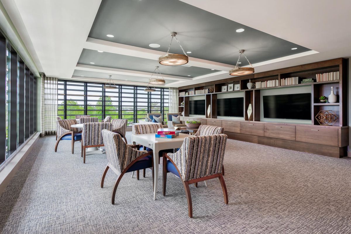 A modern lounge area with comfortable seating and large windows.