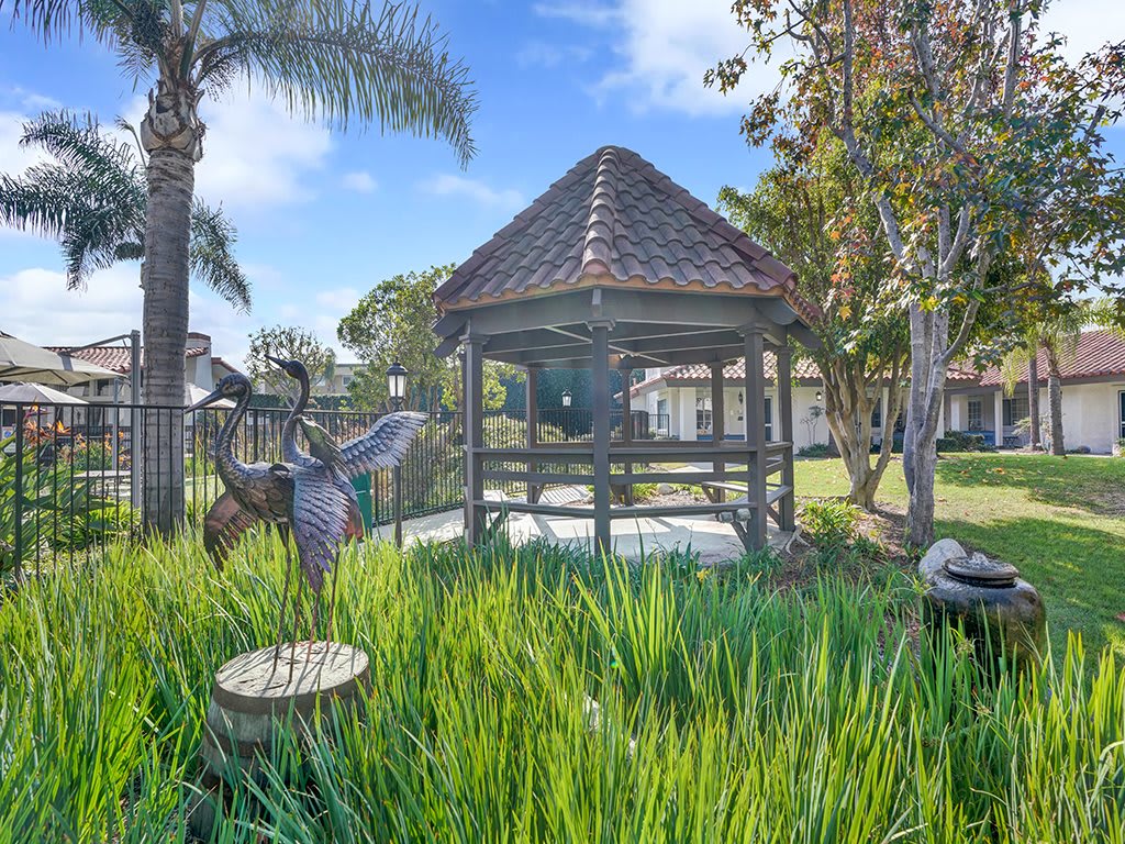 A charming gazebo surrounded by lush greenery and a serene outdoor setting.