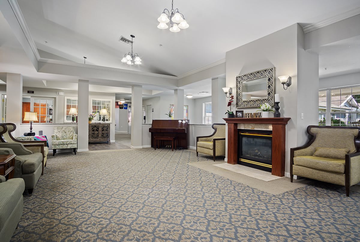 A spacious and elegantly decorated lobby area featuring a cozy fireplace, stylish furniture, and ornate lighting.