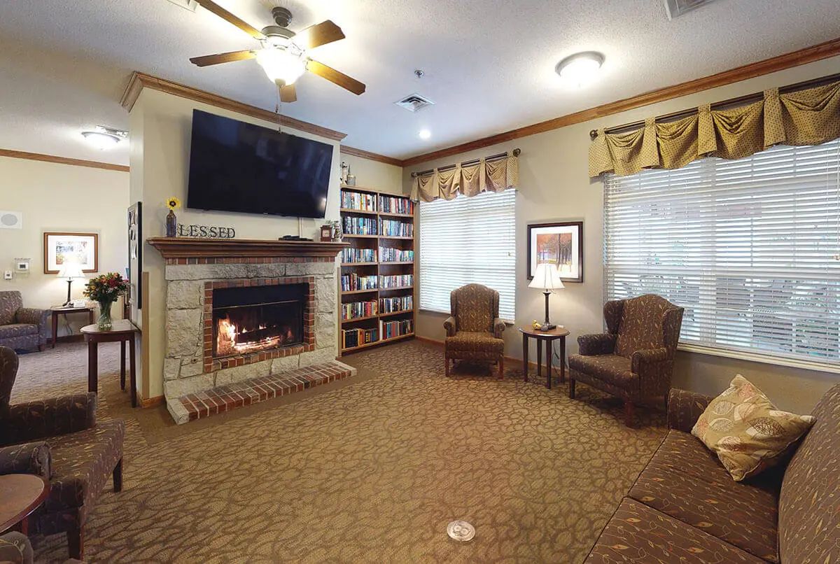 A cozy living room with a fireplace, bookshelves, television, and comfortable seating.