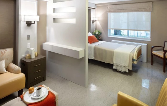 A modern hospital room with a neatly arranged bed and contemporary design elements.