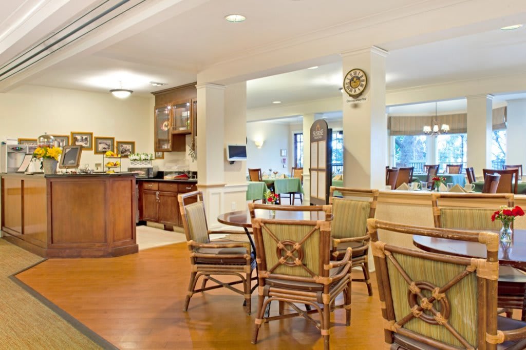 An inviting dining area with wooden tables and chairs, featuring a warm and elegant interior design.