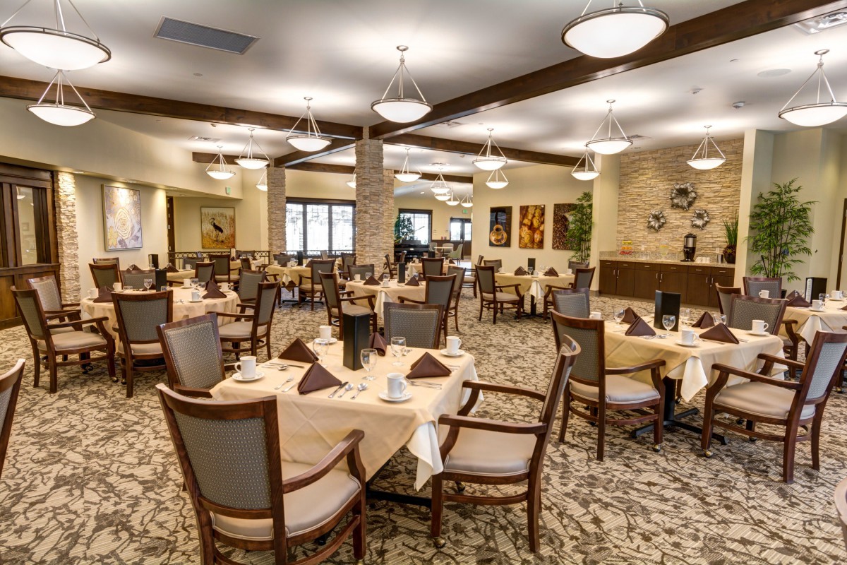 A spacious and elegantly decorated dining room with neatly arranged tables and chairs.