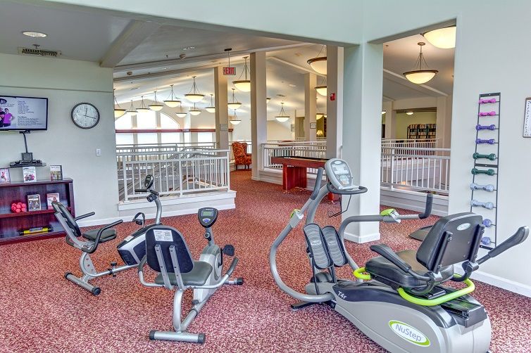 A bright and spacious fitness center with various cardio machines.
