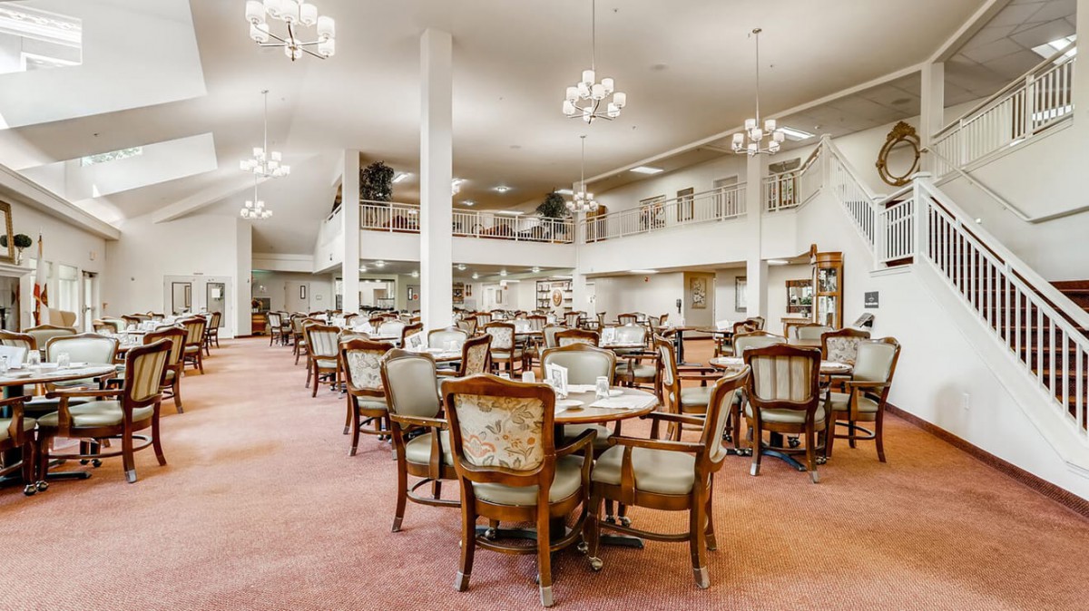 An elegant dining area with vintage chairs and tables, featuring chandeliers and classic interior design.