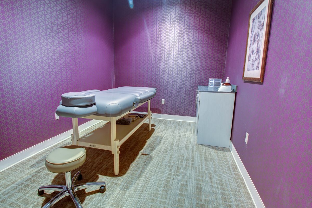 A peaceful massage room with a treatment table and soft lighting.