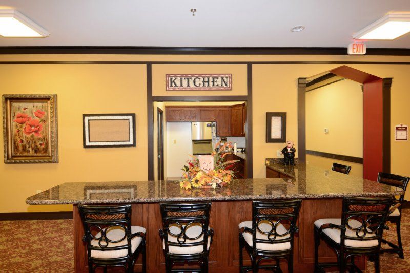 A kitchen view with a counter and four chairs in a cozy home setting.