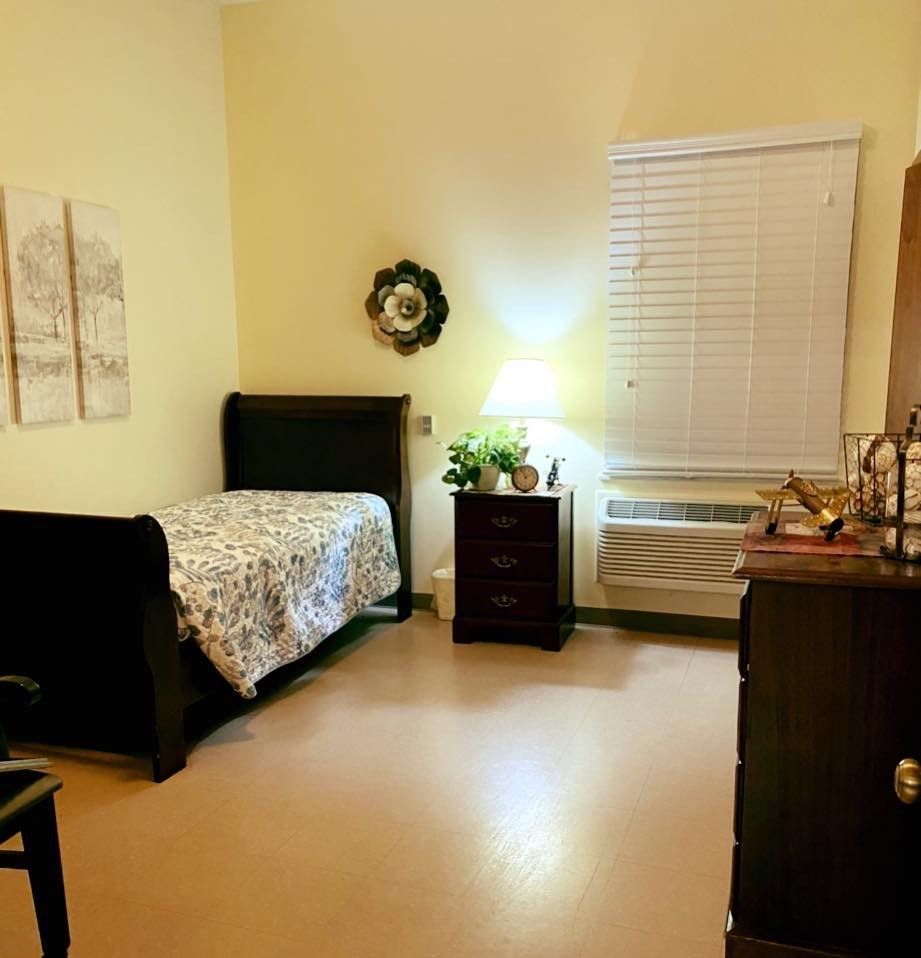 Cozy bedroom with a single bed, nightstand, and warm lighting.