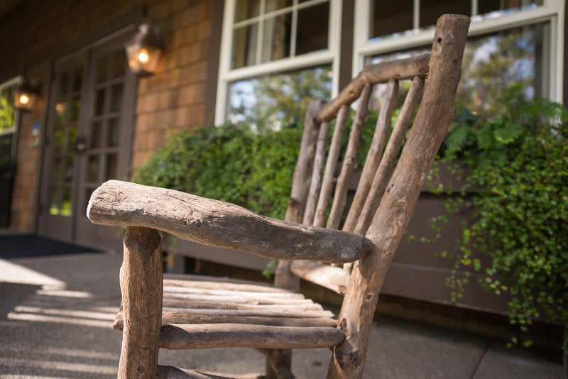 A rustic wooden chair sits on a porch, adding a natural touch to the outdoor setting.