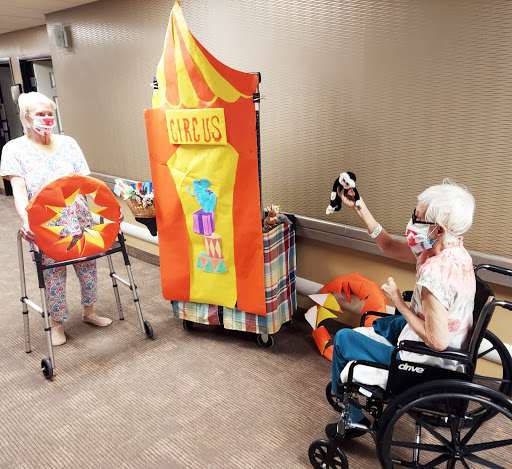 Elderly residents engage in a lively carnival-themed activity, fostering social interaction and enjoyment.